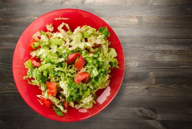  ahşap arka plan üzerinde bir tabakta lahana domates salatası