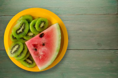 karpuz ve bir tabağa dilimlenmiş kivi  