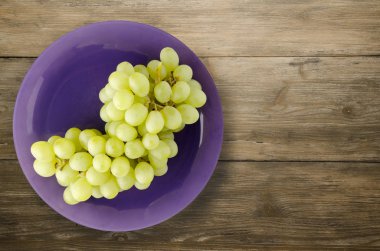 ahşap arka plan üzerinde üzüm. bir plaka üzerinde üzüm