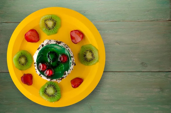Efterrätt tårta med kiwi och jordgubbar på en trä bakgrund — Stockfoto