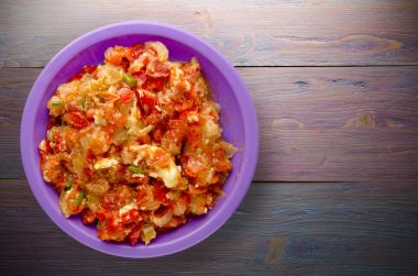 Ahşap arka plan üzerinde bir tabak içinde soğan ile haşlanmış domates 