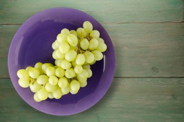 ahşap arka plan üzerinde üzüm. bir plaka üzerinde üzüm