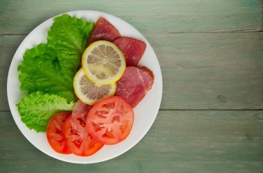 jambon salatası, domates ve limon bir plaka üzerinde. 