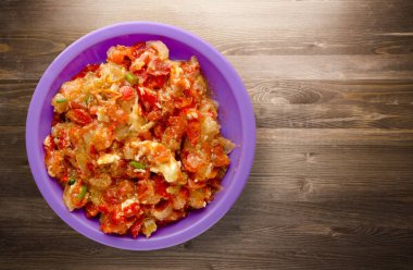 Ahşap arka plan üzerinde bir tabak içinde soğan ile haşlanmış domates 