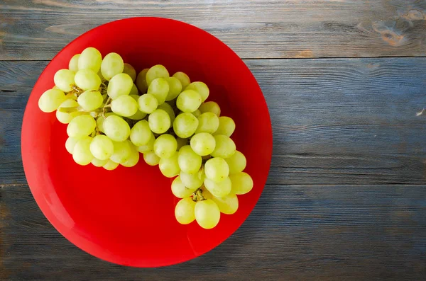 ahşap arka plan üzerinde üzüm. bir plaka üzerinde üzüm