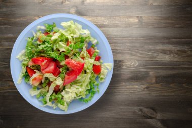  ahşap arka plan üzerinde bir tabakta lahana domates salatası