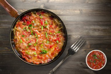 Ahşap arka plan üzerinde bir tabak içinde soğan ile haşlanmış domates 