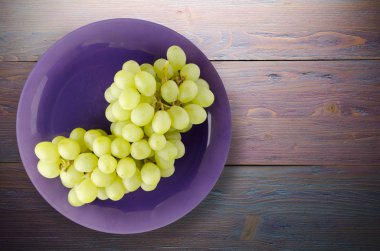 ahşap arka plan üzerinde üzüm. bir plaka üzerinde üzüm