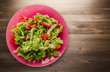  ahşap arka plan üzerinde bir tabakta lahana domates salatası