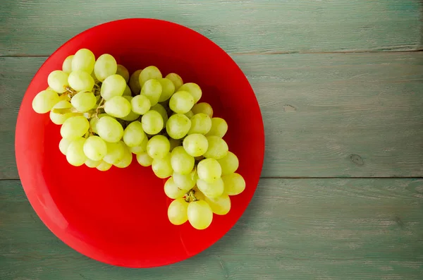ahşap arka plan üzerinde üzüm. bir plaka üzerinde üzüm
