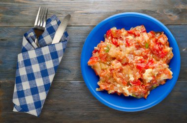 Ahşap arka plan üzerinde bir tabak içinde soğan ile haşlanmış domates 