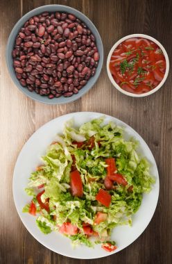  ahşap arka plan üzerinde bir tabakta lahana domates salatası