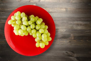 ahşap arka plan üzerinde üzüm. bir plaka üzerinde üzüm