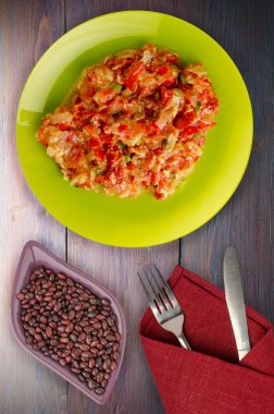 Ahşap arka plan üzerinde bir tabak içinde soğan ile haşlanmış domates 