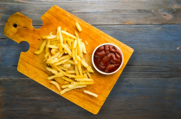 Картофель фри с кетчупом на деревянном фоне. картофель фри о — стоковое фото