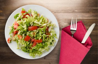  ahşap arka plan üzerinde bir tabakta lahana domates salatası