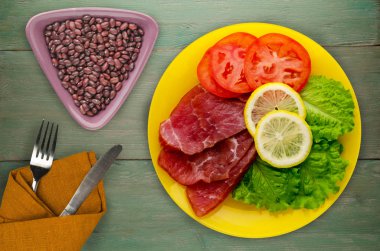 jambon salatası, domates ve limon bir plaka üzerinde. 