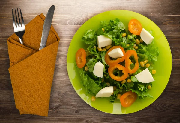 Salade van kaas, sla, maïs, peper op een houten achtergrond. V — Stockfoto