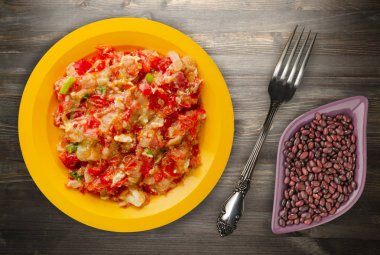 Ahşap arka plan üzerinde bir tabak içinde soğan ile haşlanmış domates 