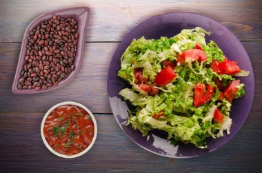  ahşap arka plan üzerinde bir tabakta lahana domates salatası