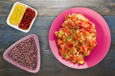 Ahşap arka plan üzerinde bir tabak içinde soğan ile haşlanmış domates 