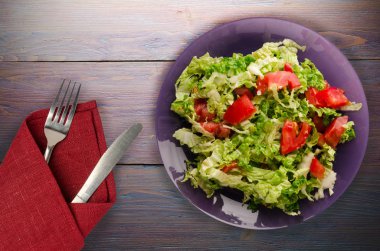  ahşap arka plan üzerinde bir tabakta lahana domates salatası