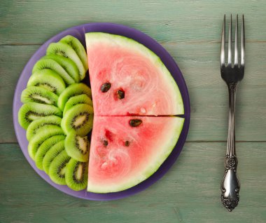 karpuz ve bir tabağa dilimlenmiş kivi  