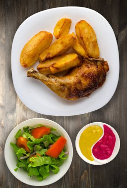 Ahşap arka plan üzerinde tavuk uyluk patates kızartması ile. 