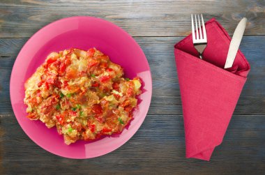 Ahşap arka plan üzerinde bir tabak içinde soğan ile haşlanmış domates 