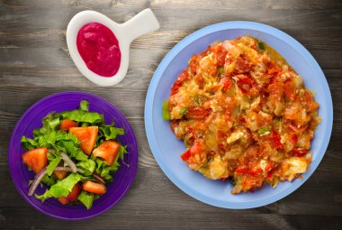 Ahşap arka plan üzerinde bir tabak içinde soğan ile haşlanmış domates 