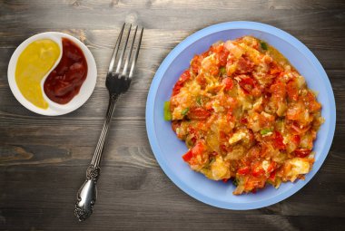 Ahşap arka plan üzerinde bir tabak içinde soğan ile haşlanmış domates 