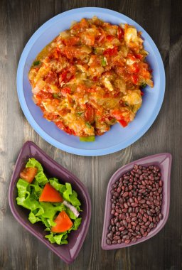 Ahşap arka plan üzerinde bir tabak içinde soğan ile haşlanmış domates 