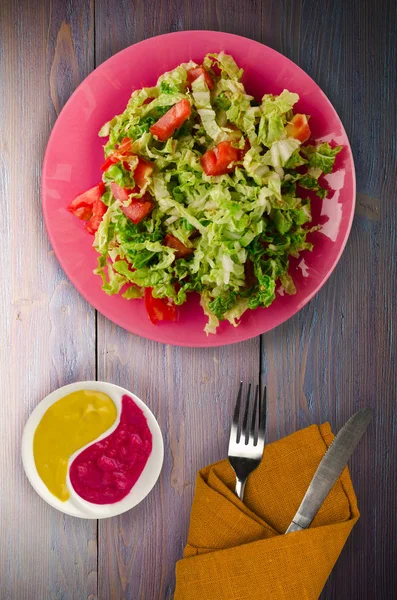 Salade de tomate au chou dans une assiette sur fond de bois — Photo