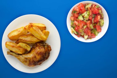 Beyaz bir tabakta kızarmış tavuk ve patates kızartması.