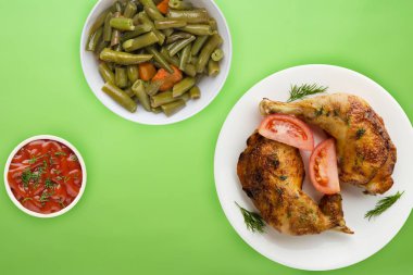 Kızarmış tavuk budu ve sebzeli beyaz tabak ve...