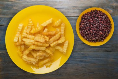 Ahşap bir arka planda, tabakta patates kızartması.