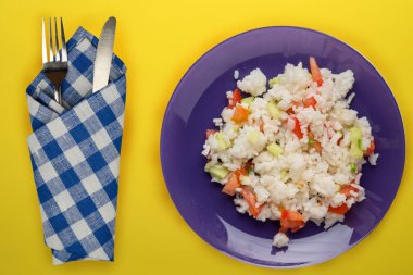 Sarı arka planda mor tabakta pirinç. Beyaz pirinç üstü vi