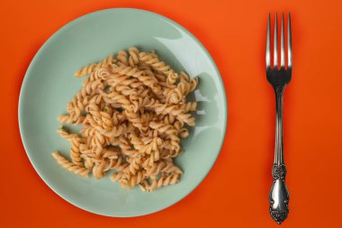 titanyum rengi arkaplanda domates soslu makarna. Turuncu arka planda Akdeniz yemekleri. sağlıklı yiyecekler