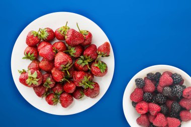Beyaz tepsi manzaralı çilekler. Arka planda çilekler var. Sağlıklı yiyecekler. vejetaryen yemeği.
