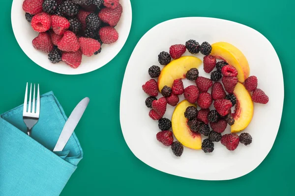 Alimentos dietéticos e saudáveis. amora-preta, framboesa, nectarina em uma chapa branca em uma chapa. Comida vegetariana em uma vista superior de fundo . — Fotografia de Stock