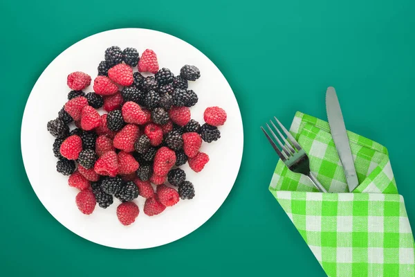 Blackberry and raspberry on a white plate. blackberry and raspberries on a background top view. Vegetarian food. — Stock Photo, Image