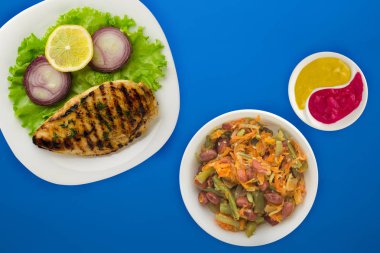 Renkli arka planda, limonlu ızgara tavuk, salata, soğan. g