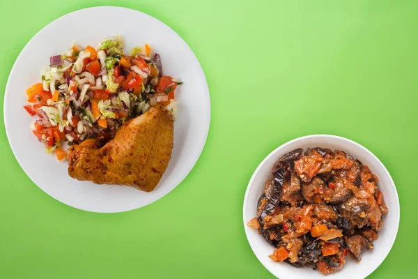 Muslos de pollo fritos con verduras en un plato blanco sobre el fondo de color. comida rápida con ensalada de verduras vista superior. alimentos poco saludables — Foto de Stock