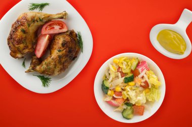 Kızarmış tavuk budu ve sebzeli beyaz tabak ve...