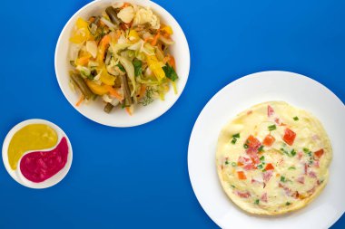 Renkli arka planda beyaz bir tabakta omlet. sağlıklı mola