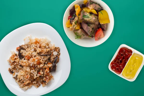 Arroz en un plato blanco con ensalada de verduras en un respaldo de color —  Fotos de Stock