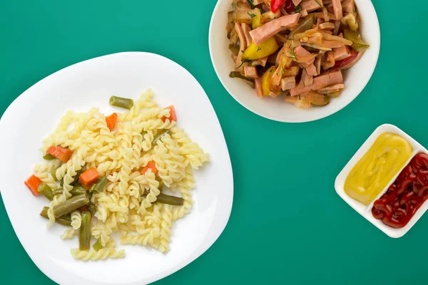 La pasta en el plato con hortalizas sobre el fondo coloreado. Medite. —  Fotos de Stock