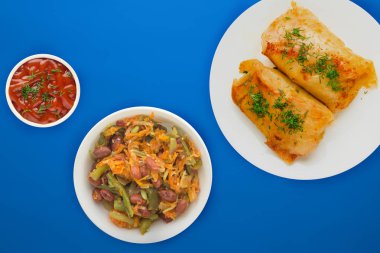  sebze salatası ve soslu beyaz bir tabakta lahana rulosu.. 