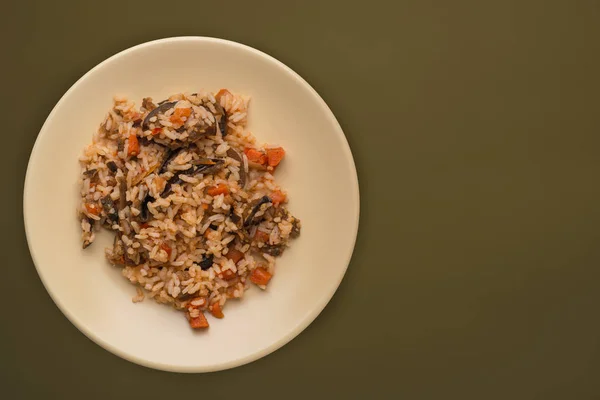 Arroz en un plato beige sobre un fondo verde marrón. arroz blanco —  Fotos de Stock