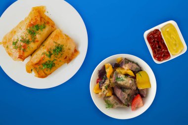  sebze salatası ve soslu beyaz bir tabakta lahana rulosu.. 